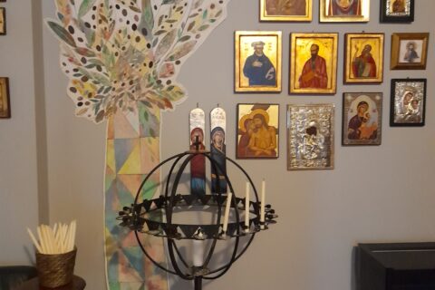 Metallinen kynttelikkö, jonka takana seinällä useita ikoneja.